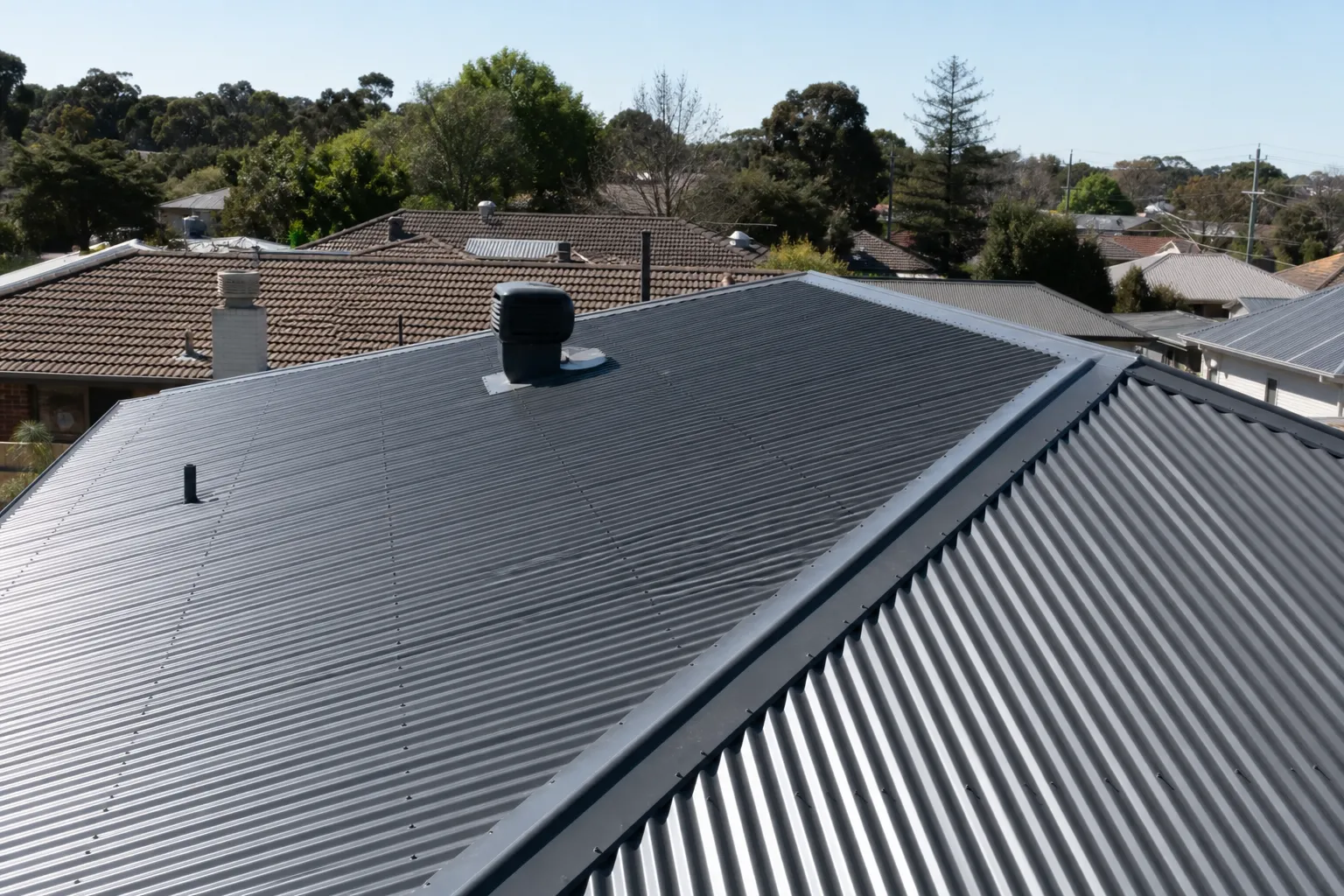 Colorbond metal roof on a modern home in a Melbourne northern-suburbs growth-corridor estate under a clear sky